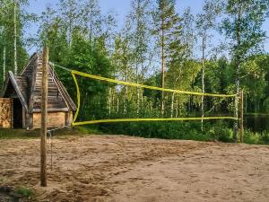 a volleyball net in the sand in front of a house at Holiday Home Riemukaari by Interhome in Lihavanpää +18 photos