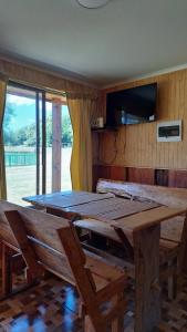 a large wooden table and benches in a room at Paraíso Rustico 1 in Curacautín