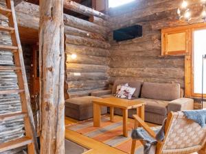 a living room with a couch and a table in a log cabin at Holiday Home Sallanhelmi e2 by Interhome in Salla +18 photos