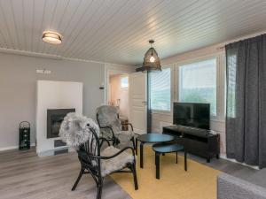 a living room with a table and chairs and a television at Holiday Home Valonsäde by Interhome in Valkeala