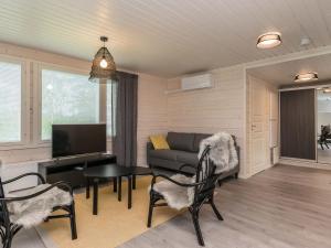 a living room with a couch and a table and chairs at Holiday Home Valonsäde by Interhome in Valkeala