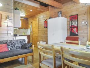 a kitchen with a table and chairs and a refrigerator at Holiday Home Lomamaja 3 by Interhome in Raattama