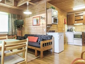 a living room with a couch and a kitchen at Holiday Home Lomamaja 3 by Interhome in Raattama