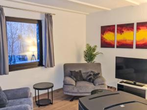 a living room with a chair and a television at Apartment Dornröschen by Interhome in Frankenau +17 photos