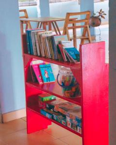 a red book shelf filled with books at REFUGE du MONT AGOU in Liatonou