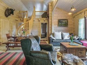 a living room with couches and a table in a cabin at Holiday Home Ruuhikari by Interhome in Ulvila