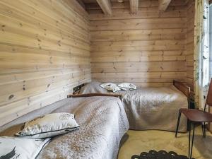 two beds in a room with wooden walls at Holiday Home Ruuhikari by Interhome in Ulvila +9 photos