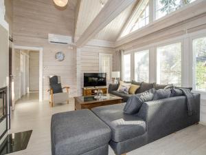 a living room with a couch and a tv at Holiday Home Villa valo by Interhome in Kolinkylä