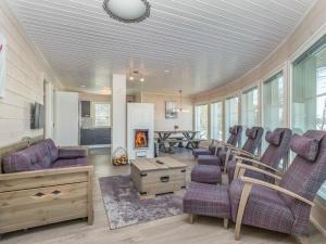a living room with purple chairs and a fireplace at Holiday Home Paula by Interhome in Lihavanpää