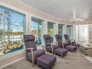 a waiting room with chairs and a table and windows at Holiday Home Paula by Interhome in Lihavanpää
