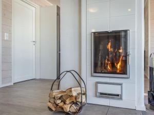 a fireplace in a living room with a pile of logs at Holiday Home Paula by Interhome in Lihavanpää +14 photos