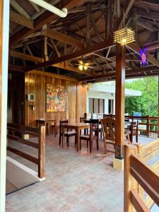 a dining room with wooden tables and chairs at Sequor Palm Villa in Siquijor
