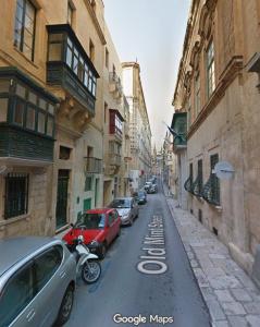 a street with cars parked on the side of the road at The Hidden Mint - Valletta in Valletta