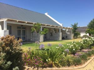 a house with a garden of flowers in the yard at Sempurna Estate in McGregor