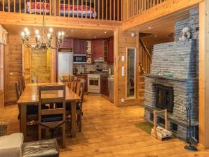 a kitchen and dining room with a table and a fireplace at Holiday Home Ylläskaira a by Interhome in Äkäslompolo