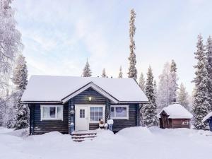 a house with two dogs standing in the snow at Holiday Home Isopyhänmaa by Interhome in Salla