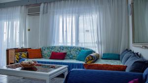 a living room with a blue couch with colorful pillows at Apartment 45m2 in Asprovalta in Asprovalta +29 photos