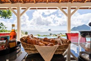 a basket of bread sitting on a table with a window at Villa Lueurs du Rocher in Le Diamant