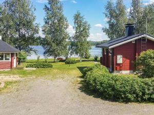 a red cabin with a view of the water at Holiday Home Eden by Interhome in Kuusa