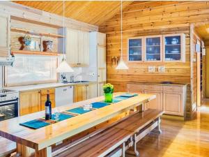 a kitchen with wooden walls and a wooden table at Holiday Home Sinikuono by Interhome in Ylläsjärvi