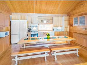a kitchen with a table and a white refrigerator at Holiday Home Sinikuono by Interhome in Ylläsjärvi +21 photos