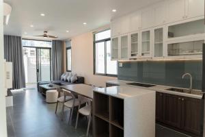 a kitchen with a table and some chairs in it at Biệt thự Hồ Tràm 3224 in Xuyên Mộc