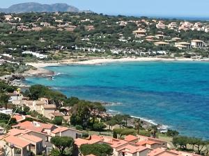 a view of a beach with houses and the ocean at Chez Béa in Lumio