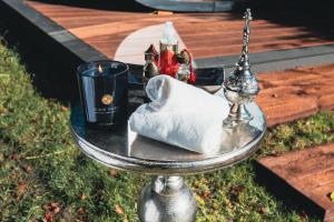 a glass table with a candle and a towel at Suites Romantiques avec Jacuzzi - Marne-La-Vallée - Le Jardin De Vos Secrets in Mouroux