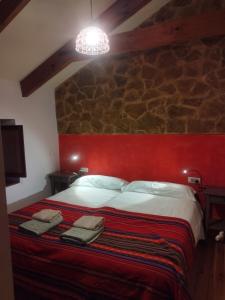 a bedroom with a large bed with a red headboard at Casa Rural Lamadretierra in Villamejil