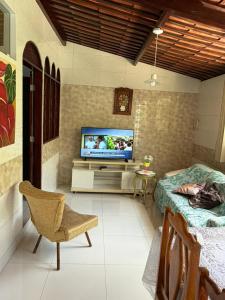 a living room with a television and a bed at Pousada 48 Graus - Caldas do Jorro BA in Poço Redondo