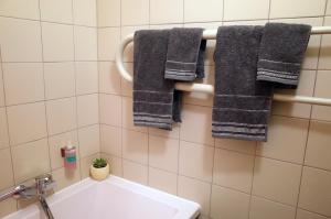 a bathroom with gray towels hanging on a wall at Apartment City Heart in Valmiera +19 photos