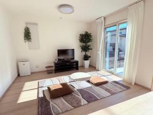 a living room with a table and a large window at Hotel Sakura 宇都宮 in Utsunomiya