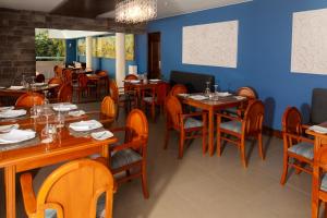 a restaurant with wooden tables and chairs and blue walls at La Maison d'Elise in Arequipa
