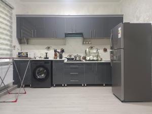 a kitchen with black cabinets and a washing machine at Bobur Guest House in Khiva