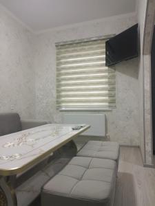 a room with a table and a bench and a window at Bobur Guest House in Khiva