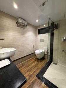 a bathroom with a toilet and a glass shower at Hotel Beach Garden in Mumbai +65 photos
