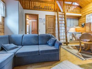 a living room with a blue couch and a kitchen at Holiday Home Lomapesä 2b by Interhome in Kotila