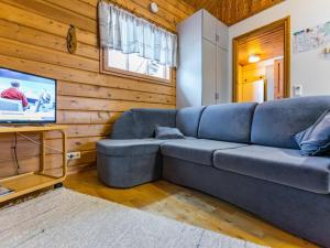 a living room with a blue couch and a tv at Holiday Home Lomapesä 2b by Interhome in Kotila