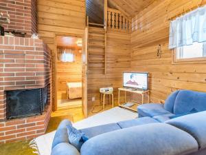 a living room with a couch and a fireplace at Holiday Home Lomapesä 2b by Interhome in Kotila