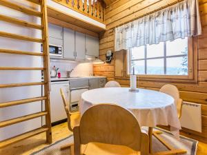 a kitchen and dining room with a table and chairs at Holiday Home Lomapesä 2b by Interhome in Kotila