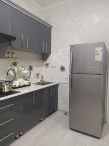 a kitchen with a stainless steel refrigerator and a sink at Bobur Guest House in Khiva +3 photos