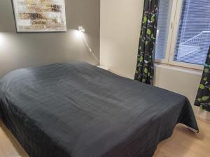 a bedroom with a bed with a gray blanket at Holiday Home Levin stara c11 by Interhome in Levi