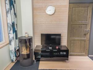 a living room with a television and a clock on a wall at Holiday Home Levin stara c11 by Interhome in Levi