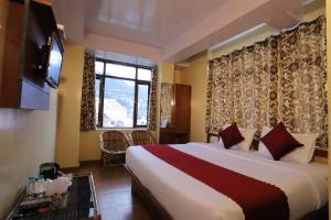 a hotel room with a large bed and a window at Harmony Sentiments in Shimla