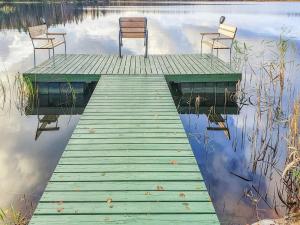two chairs and a wooden dock on a lake at Holiday Home Nummentähti by Interhome in Tammela