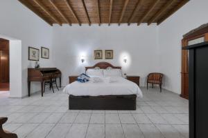 a bedroom with a bed and a desk and a piano at La Casucha - Typical Canarian House By Lanzarote Vacation Homes in Tías