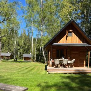 a log cabin with a table and chairs on a deck at Geofond Chaty in Chotěboř