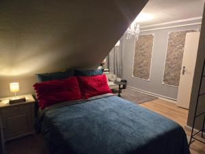 a bedroom with a bed with red and blue pillows at Gästezimmer vom Restaurant Saustall in Mestlin