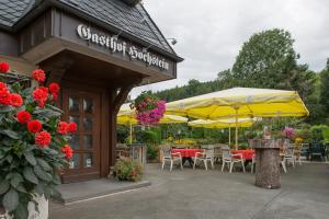 a restaurant with tables and chairs and umbrellas at Gasthof Hochstein in Meschede