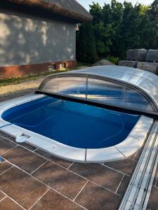 a swimming pool with a curved roof on a house at Füle-Müle Élményház in Füle